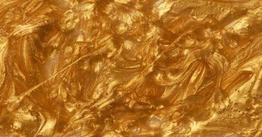 Sample of golden glitter gel with small particles, texture of highlighter cosmetics photo