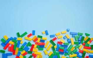 Multi-colored plastic cubes of a children's designer on a blue background, top view photo