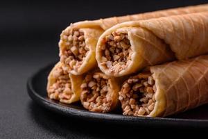 Delicious crispy wafer rolls with cream filling with nuts photo