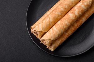 Delicious crispy wafer rolls with cream filling with nuts photo