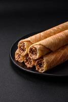 Delicious crispy wafer rolls with cream filling with nuts photo