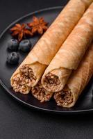 Delicious crispy wafer rolls with cream filling with nuts photo