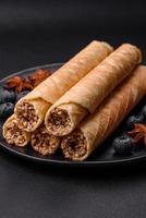 Delicious crispy wafer rolls with cream filling with nuts photo