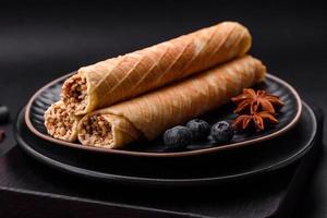 Delicious crispy wafer rolls with cream filling with nuts photo