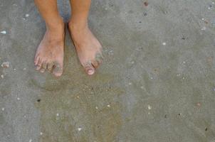 Feet Standing on Sand Beach Concept Background photo