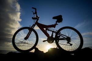 montaña bicicleta y puesta de sol foto