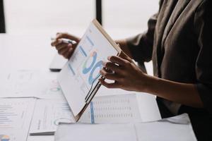 Financial analysts analyze business financial reports on a digital tablet planning investment project during a discussion at a meeting of corporate showing the results of their successful teamwork. photo