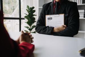 Close up view of job interview in office, focus on resume writing tips, employer reviewing good cv of prepared skilled applicant, recruiter considering application, hr manager making hiring decision photo