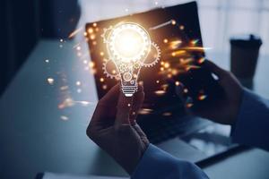 Hand of businessman holding illuminated light bulb with network connection line, idea, innovation and inspiration concept. concept creativity with bulbs that shine glitter. photo