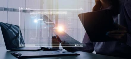 Project manager working with Gantt chart schedule to plan tasks and deliverables. Scheduling activities with a planning software, Corporate strategy for finance, operations, sales, marketing. photo