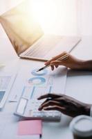 Financial analysts analyze business financial reports on a digital tablet planning investment project during a discussion at a meeting of corporate showing the results of their successful teamwork. photo