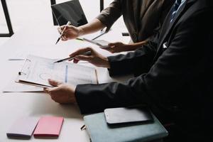 Financial analysts analyze business financial reports on a digital tablet planning investment project during a discussion at a meeting of corporate showing the results of their successful teamwork. photo