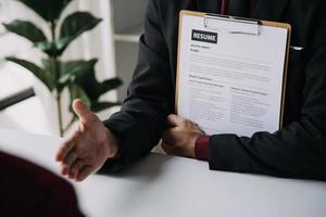 Close up view of job interview in office, focus on resume writing tips, employer reviewing good cv of prepared skilled applicant, recruiter considering application, hr manager making hiring decision photo