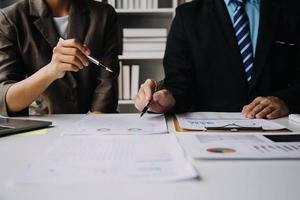 Financial analysts analyze business financial reports on a digital tablet planning investment project during a discussion at a meeting of corporate showing the results of their successful teamwork. photo