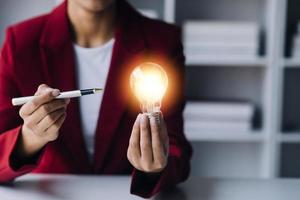 Business People touch Light bulb.Concept of Ideas for Success. Concept with Innovation Invention. Success Starting from a new idea to innovative technology based on data from the Internet, big data. photo