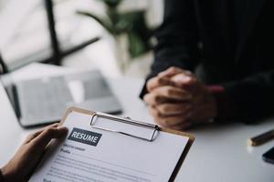 cerca arriba ver de trabajo entrevista en oficina, atención en currículum escritura consejos, empleador revisando bueno CV de preparado experto solicitante, reclutador considerando solicitud, hora gerente haciendo contratación decisión foto