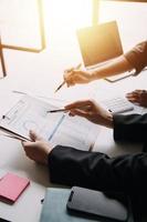 Financial analysts analyze business financial reports on a digital tablet planning investment project during a discussion at a meeting of corporate showing the results of their successful teamwork. photo