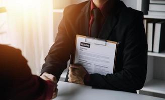 Close up view of job interview in office, focus on resume writing tips, employer reviewing good cv of prepared skilled applicant, recruiter considering application, hr manager making hiring decision photo