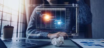 Project manager working with Gantt chart schedule to plan tasks and deliverables. Scheduling activities with a planning software, Corporate strategy for finance, operations, sales, marketing. photo