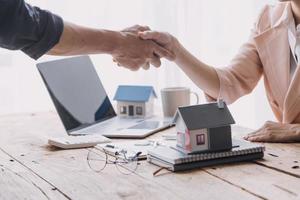 Home buyers meet and negotiate with real estate agents about renting or buying a home in the office. photo