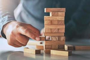 close up of hand businessman playing block wood photo