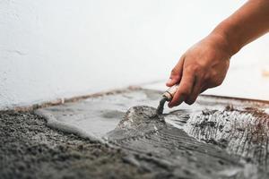 trabajador enlucido cemento en construcción sitio foto