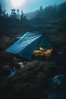 Wilderness Survival. Bushcraft Tent Under the Tarp in Heavy Rain, Embracing the Chill of Dawn. A Scene of Endurance and Resilience photo