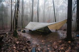 Wilderness Survival. Bushcraft Tent Under the Tarp in Heavy Rain, Embracing the Chill of Dawn. A Scene of Endurance and Resilience photo