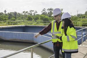 los ingenieros ambientales trabajan en plantas de tratamiento de aguas residuales, la ingeniería de suministro de agua trabaja en la planta de reciclaje de agua para su reutilización, los técnicos y los ingenieros discuten el trabajo juntos. foto