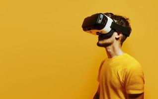 Side view of a man put on VR glasses isolated over yellow background. photo