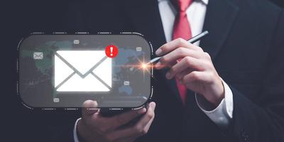 man reading electronic mail from smartphone,Email marketing and newsletter concept,Digital communication with email messages,Sending and receiving messages online with the email icon photo