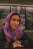 A woman with purple hair looking at the camera photo