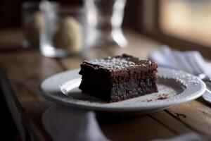 Delicious homemade chocolate brownie in white ceramic plate on rustic wooden table. . Selective focus photo