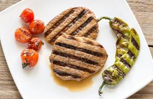 Beef steaks on the white square plate photo
