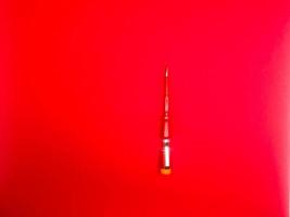 red screwdriver insulated with red background photo