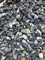 Grey ballast stone surface. Texture of ballast rock bed. Floor covered by gray rocks small pebble materials. photo