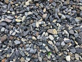 Grey ballast stone surface. Texture of ballast rock bed. Floor covered by gray rocks small pebble materials. photo