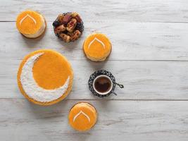 Delicious homemade golden cake with a Crescent moon, served with black coffee and dates. Ramadan background, copy space photo