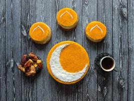 Homemade golden cake with a Crescent moon, served with black coffee and dates. Ramadan background photo