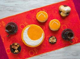 Homemade golden cake with a Crescent moon, served with tea cup and dates. Ramadan background photo