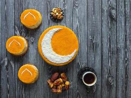 Homemade golden cake with a Crescent moon, served with black coffee and dates. Ramadan background photo