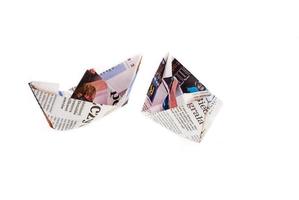 origami ship from newspaper on white background photo