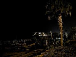night view of the turkish city of alanya with lights on the hill photo