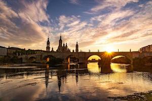 pintoresco puesta de sol en un verano día en el ciudad de zaragoza en España con vista a el río y el catedral foto