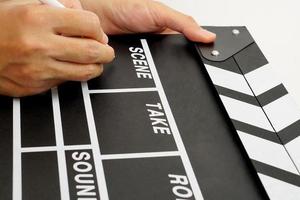 Focus the hand is holding clapperboard or movie slate black color and marker pen. Cinema industry concept. photo