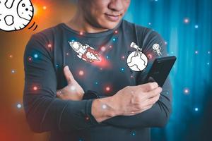 The concept of using digital media, technology, and social media. Surfing online, a man using a smartphone to play or use Space travel simulation, remote work concept, work from home via the Internet photo