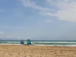 l seaside landscape with two sun loungers on the beach on the shores of the turquoise sea on a warm summer day photo