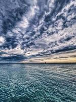 seaside landscape with clouds and sailboat on the horizon Alicante Spain photo