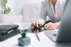 Social media day concept. Female freelancer starting working day early in living room for website with digital tablet. Businesswoman working in home office. Woman communicating with online technology. photo