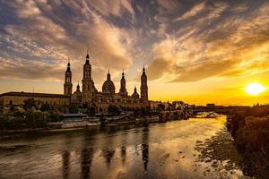 pintoresco puesta de sol en un verano día en el ciudad de zaragoza en España con vista a el río y el catedral foto